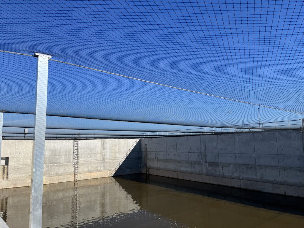 Filet de protection au-dessus de l’eau du bassin d’orage et de ses parois en béton