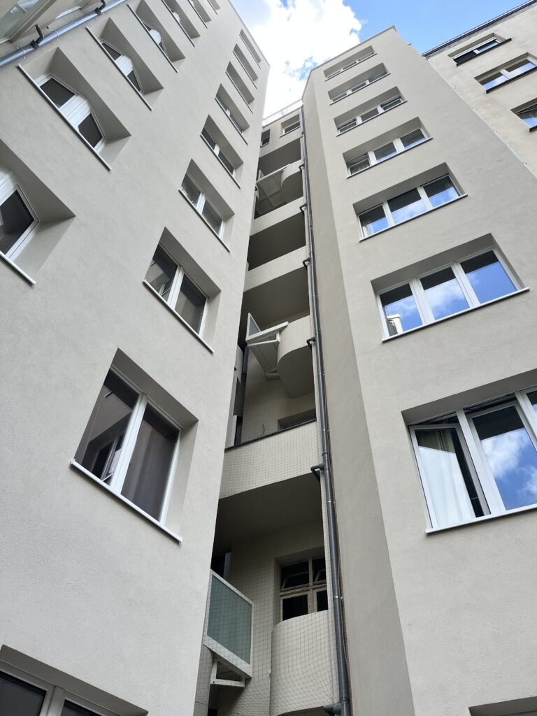 Vue depuis la cour d’un immeuble avec un filet devant les balcons centraux